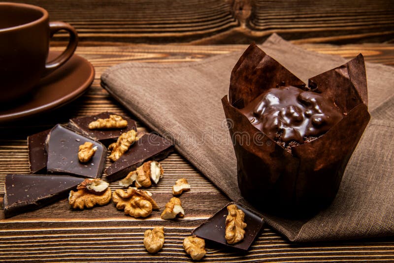 Queque do chocolate em um guardanapo entre partes de chocolate e de nozes imagem de stock royalty free Queque do chocolate em um guardanapo entre partes de chocolate e de nozes imagem de stock royalty free
