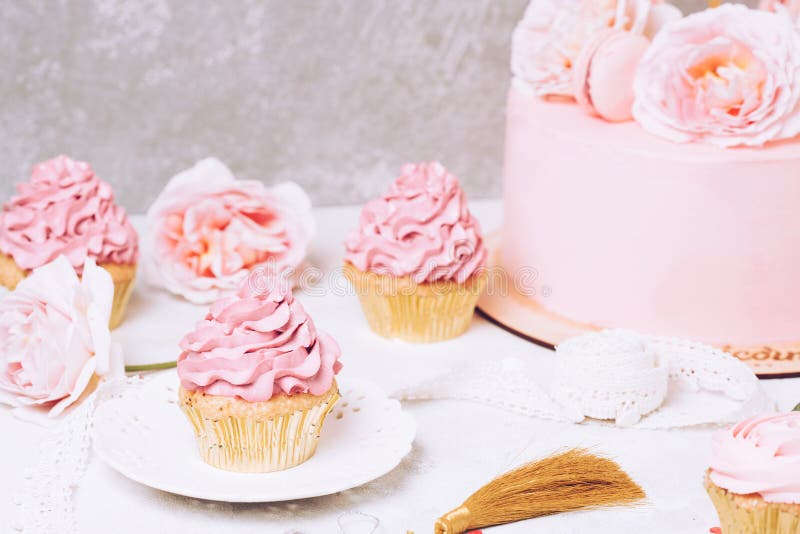 Queques cor-de-rosa com rosas e bolo do feriado Festivo e brilhante Conceito da celebração do casamento fotografia de stock Queques cor-de-rosa com rosas e bolo do feriado Festivo e brilhante Conceito da celebração do casamento fotografia de stock