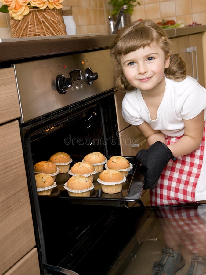 Little girl baking muffins in the kitchen. Little girl baking muffins in the kitchen