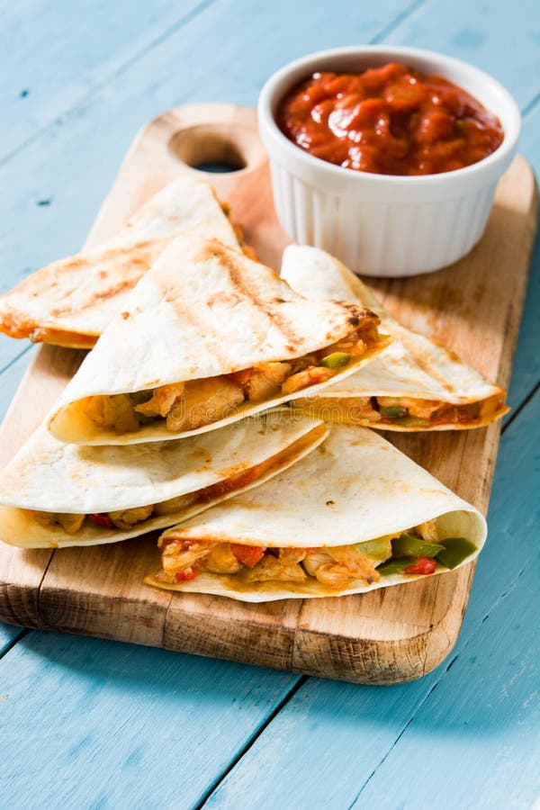 Quesadilla mexicano con el pollo, el queso y pimientas en la madera azul imagenes de archivo Quesadilla mexicano con el pollo, el queso y pimientas en la madera azul imagenes de archivo