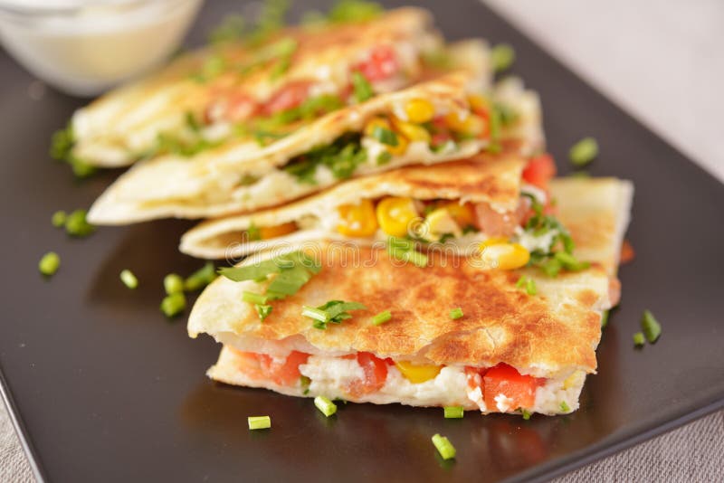 Vegetarian quesadilla with sour cream. Selective focus on the front wedge. Vegetarian quesadilla with sour cream. Selective focus on the front wedge