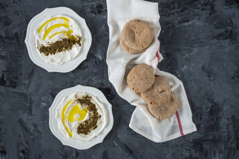 Queso de la leche de la cabra blanca suave de Oriente Medio del labaneh de Labneh con el aceite de oliva, aceitunas, za ‘atar, li fotos de archivo Queso de la leche de la cabra blanca suave de Oriente Medio del labaneh de Labneh con el aceite de oliva, aceitunas, za ‘atar, li fotos de archivo