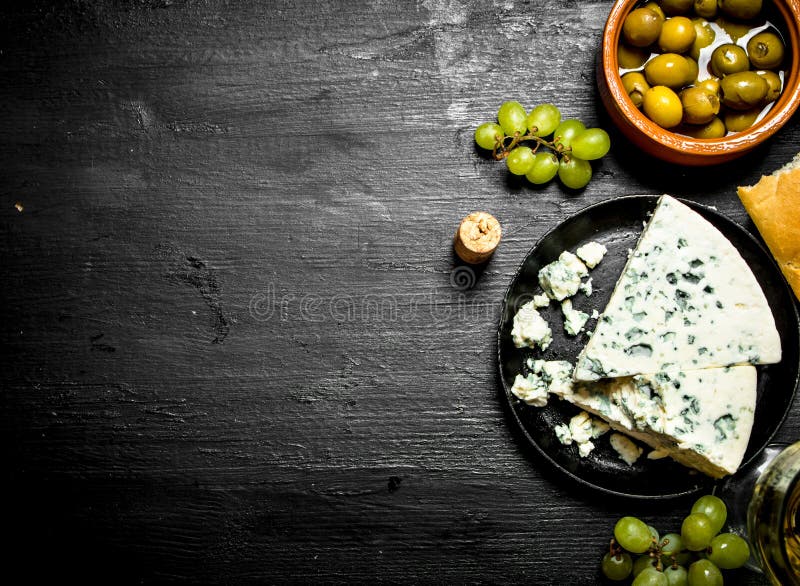 Queso verde, aceitunas y uvas blancas imagen de archivo libre de regalías Queso verde, aceitunas y uvas blancas imagen de archivo libre de regalías