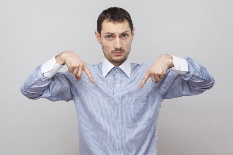 Qui e destra sapere Ritratto dell'uomo d'affari bello serio della setola nella condizione blu classica della camicia e di esame d immagini stock libere da diritti Qui e destra sapere Ritratto dell'uomo d'affari bello serio della setola nella condizione blu classica della camicia e di esame d immagini stock libere da diritti