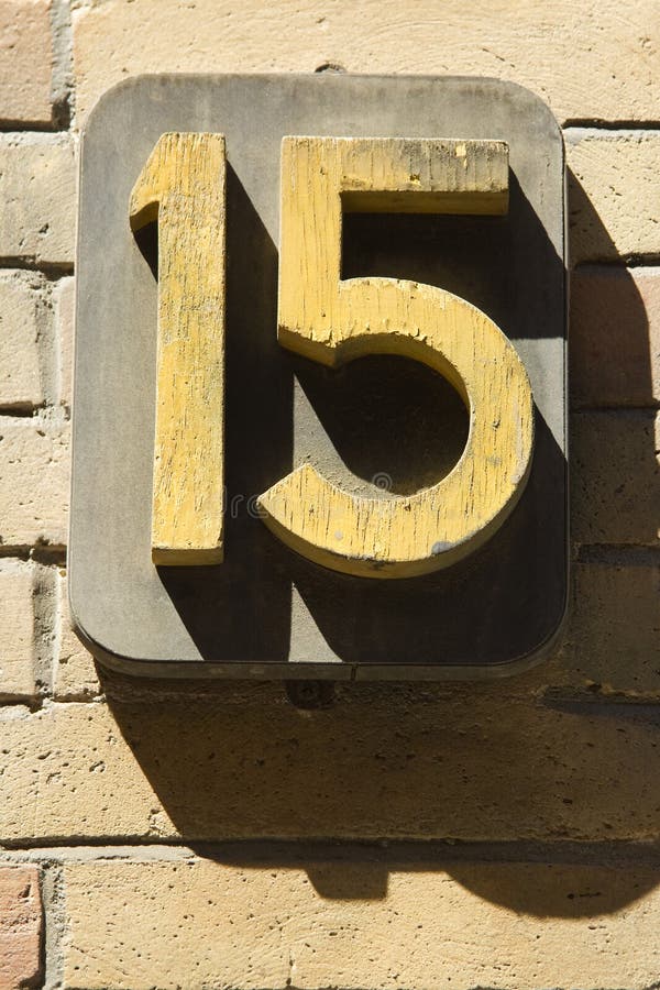 Bold number fifteen on sandstone brick wall. Bold number fifteen on sandstone brick wall