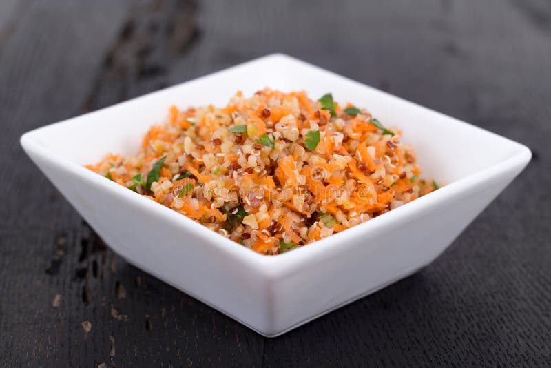 Quinoa and bulgur carrot salad over black table