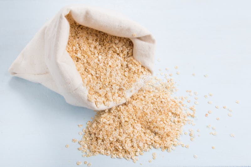 Quinoa flakes in a bag rolled top on a blue wooden board stock photo Quinoa flakes in a bag rolled top on a blue wooden board stock photo