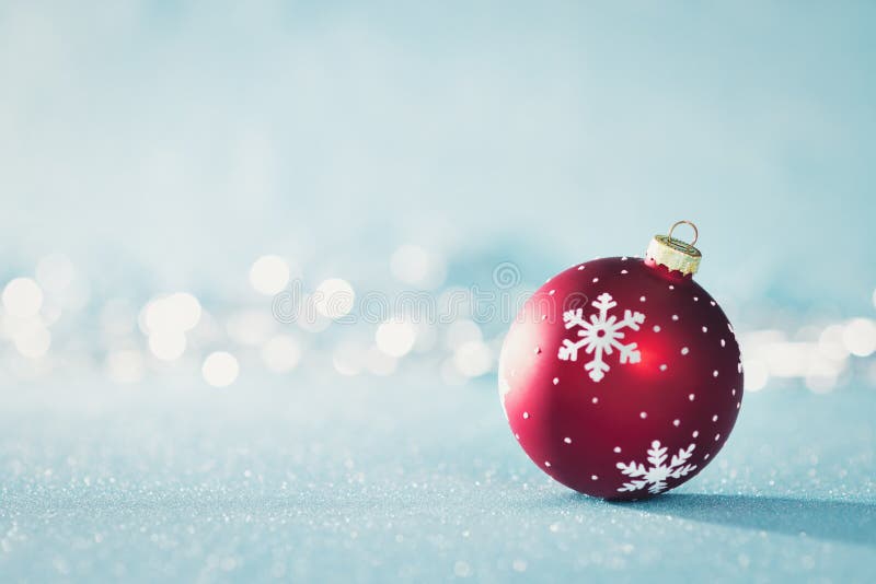 Quinquilharia vermelha brilhante do Natal no país das maravilhas do inverno Fundo azul do Natal com luzes de Natal defocused