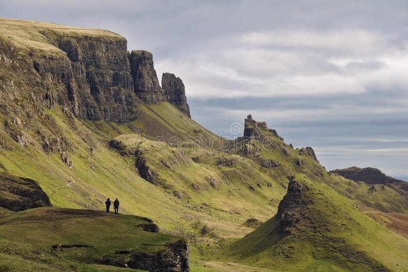 Quiraing, остров Skye, Шотландии - эксцентричного скалистого ландшафта при 2 человеческих диаграммы стоя на скале на переднем пла стоковые изображения rf