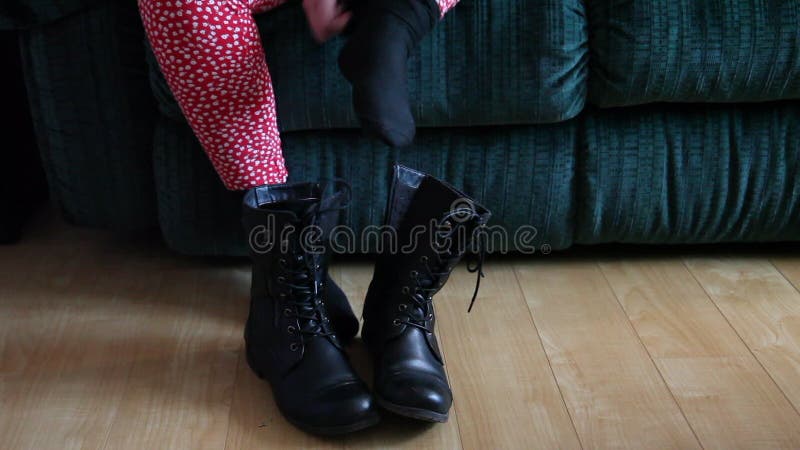 Quitando botas de invierno almacen de metraje de vídeo