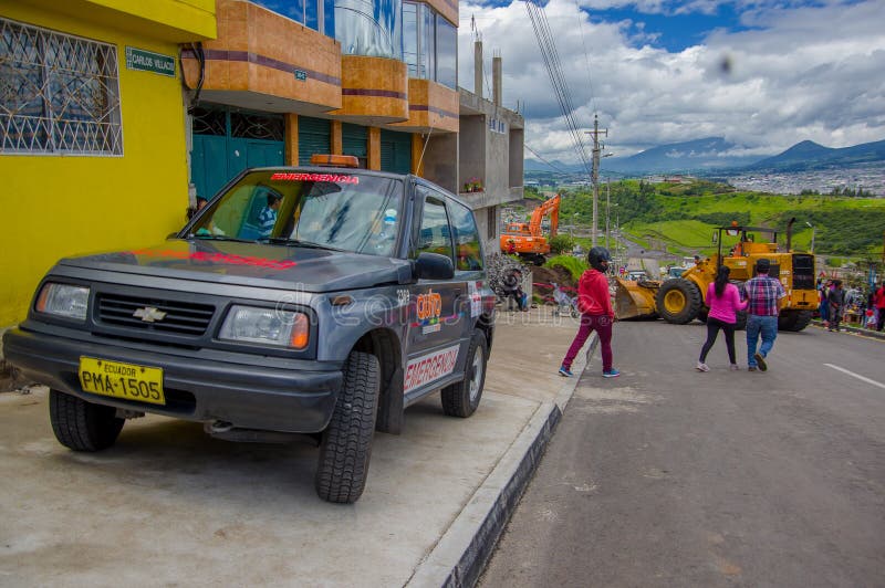 Quito, Ecuador - abril, 17, 2016: Grupo de personas no identificado que mira la destrucción causada por el terremoto, y machiner imagen de archivo Quito, Ecuador - abril, 17, 2016: Grupo de personas no identificado que mira la destrucción causada por el terremoto, y machiner imagen de archivo