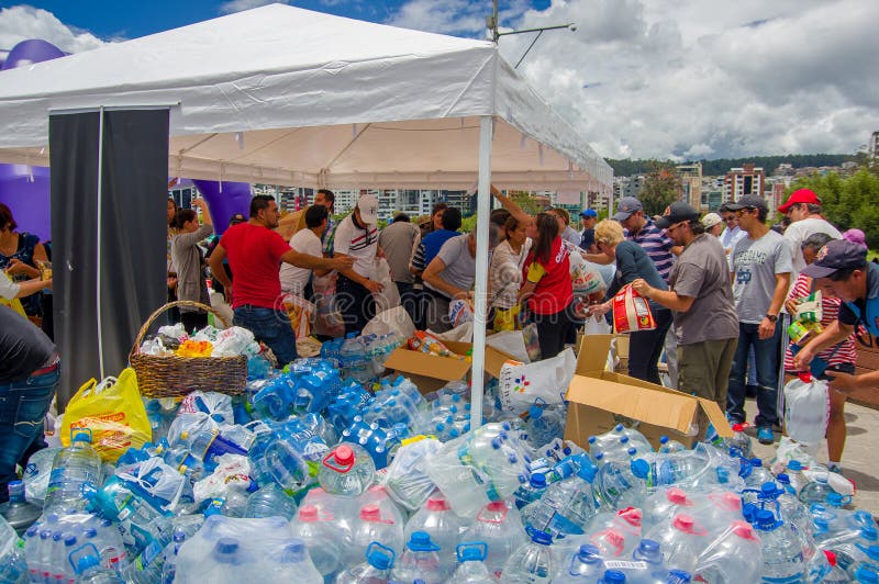 Quito, Ecuador - abril, 17, 2016: Los ciudadanos no identificados de Quito que proporcionan ayuda humanitaria riegan para los sup