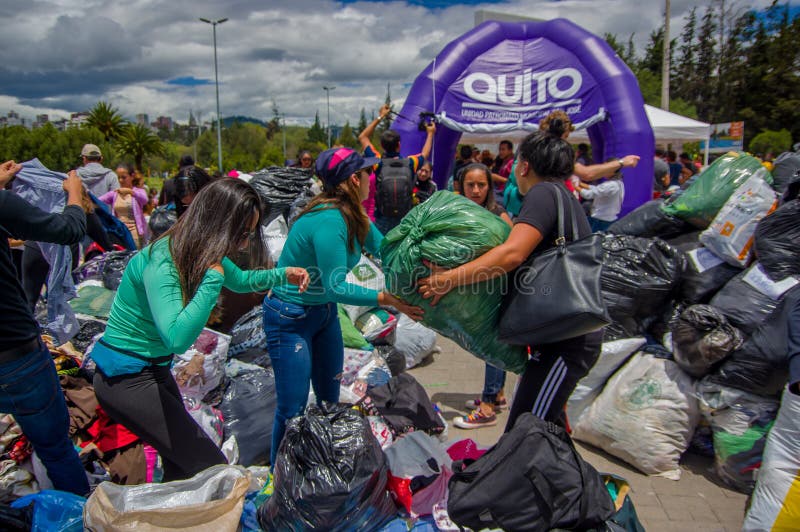 Quito, Ecuador - April, 17, 2016: Niet geïdentificeerde burgers die van Quito hulp bij rampenvoedsel, kleren, geneeskunde verstre stock foto Quito, Ecuador - April, 17, 2016: Niet geïdentificeerde burgers die van Quito hulp bij rampenvoedsel, kleren, geneeskunde verstre stock foto