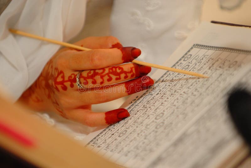 Bride reading Quran with henna on hands. Bride reading Quran with henna on hands