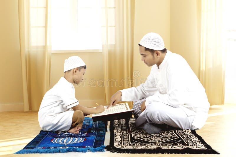 Quran för barnfaderundervisning till hans son royaltyfri fotografi Quran för barnfaderundervisning till hans son royaltyfri fotografi
