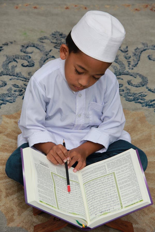 Quran muçulmano da leitura do menino fotografia de stock Quran muçulmano da leitura do menino fotografia de stock