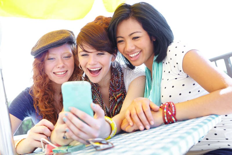 What a great photo. A group of adolescent girls laughing as they look at something on a smartphone screen. What a great photo. A group of adolescent girls laughing as they look at something on a smartphone screen