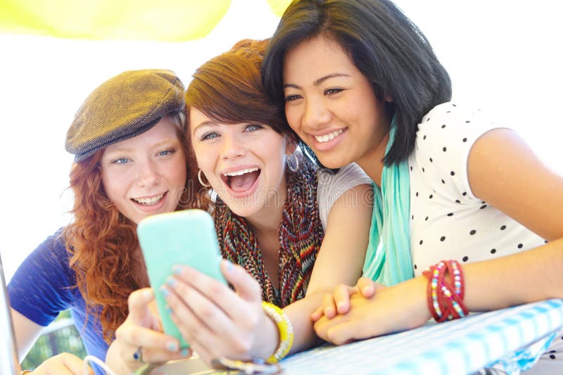 What a funny picture. A group of adolescent girls laughing as they look at something on a smartphone screen. What a funny picture. A group of adolescent girls laughing as they look at something on a smartphone screen