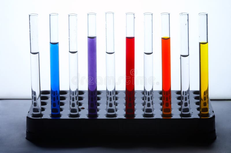 Glass test tubes standing in a line filled with colorful liquids. Glass test tubes standing in a line filled with colorful liquids