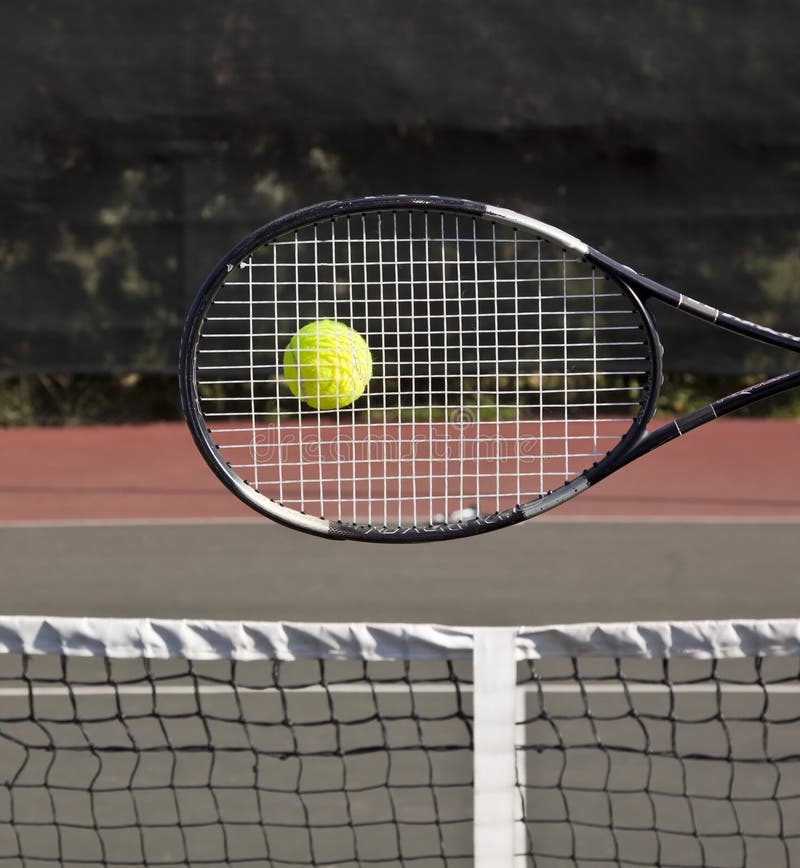 Racchetta con la sfera di tennis sulla corte fotografie stock Racchetta con la sfera di tennis sulla corte fotografie stock