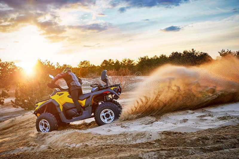 Racing Powerful Quad Bike on the Difficult Sand in the Summer Stock