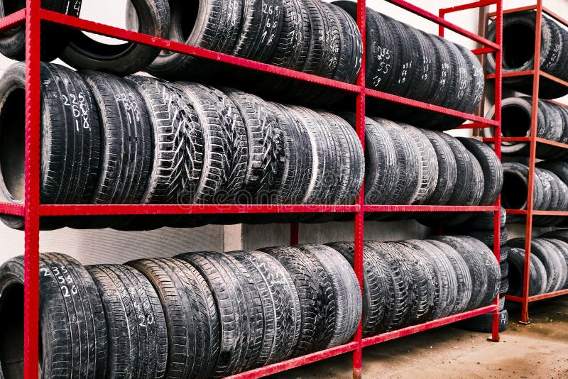 Racks of Old Tires. Old Car Tires Sit on a Red Metal Rack in a