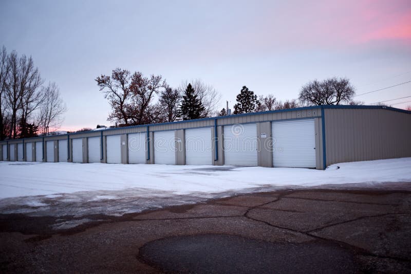 Rad av garage i vintersnö på solnedgången arkivfoton Rad av garage i vintersnö på solnedgången arkivfoton