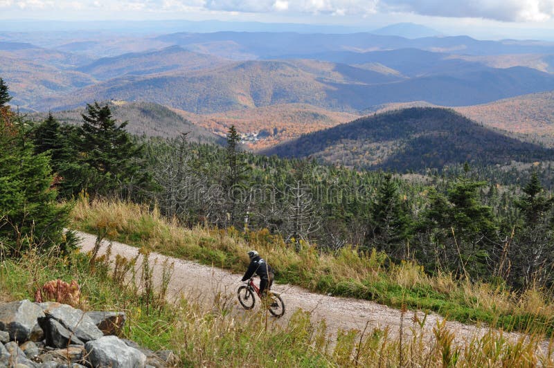 A lone mountain biker makes their way down a Vermont mountain on an autumn day. A lone mountain biker makes their way down a Vermont mountain on an autumn day.