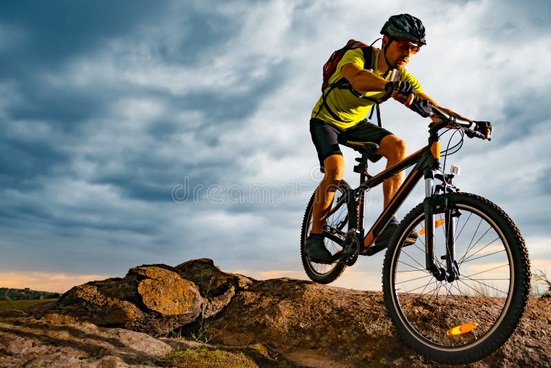 Radfahrer, der die Mountainbike auf Rocky Trail bei Sonnenuntergang reitet Extremer Sport und radfahrendes Konzept Enduro