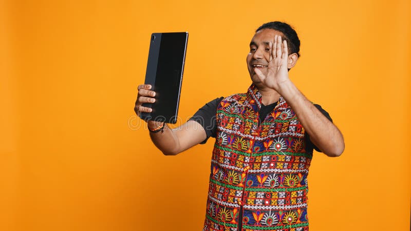 Radiant man saluting vän över videokamerans bakgrund online arkivbilder