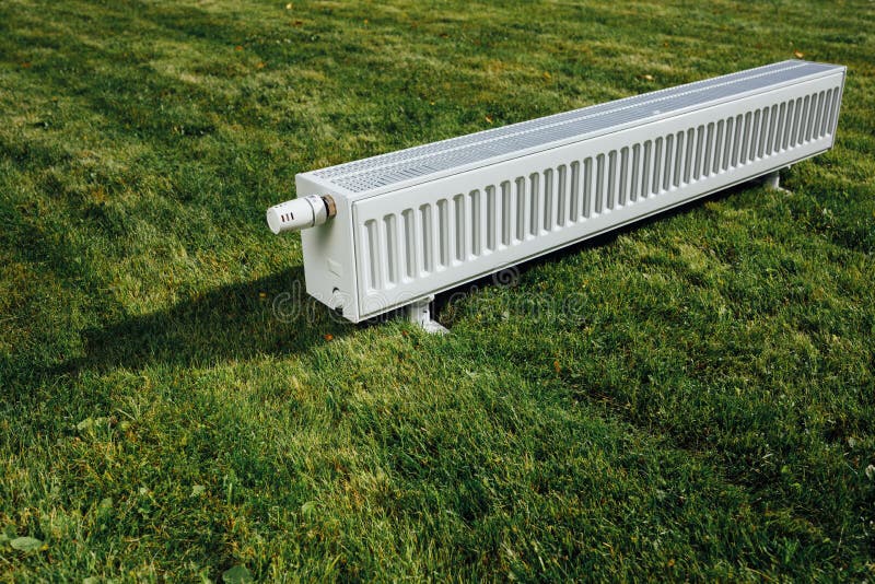 Radiator on Green Lawn, Ecological Heating Concept Stock Photo Image