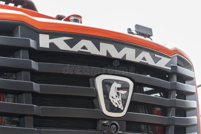 Radiator grill, manufacturer`s logo and parts of the self-driving system on the hood of the heavy hybrid dump truck KAMAZ-6561