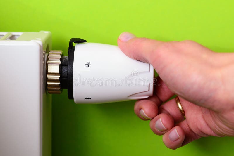 Radiatorthermostaat en hand - GROENE MACHTSenergie - besparingsconcept royalty-vrije stock afbeelding Radiatorthermostaat en hand - GROENE MACHTSenergie - besparingsconcept royalty-vrije stock afbeelding