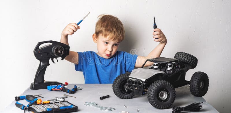 Radio Controlled Models: a Little Boy in a Blue T-shirt is Repairing His RC  Car Buggy. Stock Photo - Image of leisure, parent: 140764506