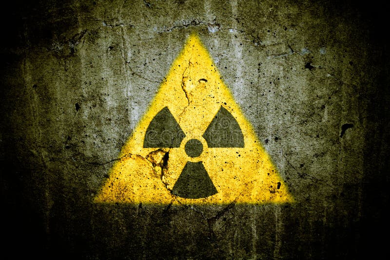 Radioactive atomic nuclear ionizing radiation danger warning symbol in triangular shape painted massive cracked concrete wall