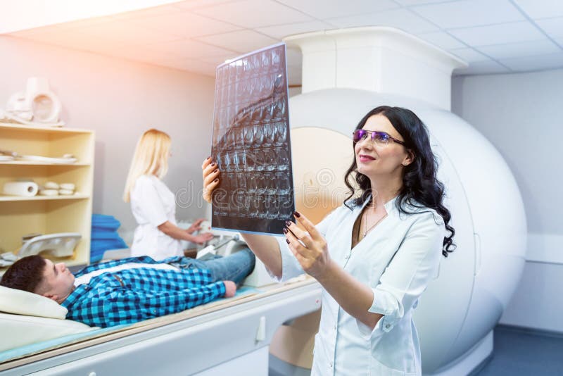 Radiologe mit männlichen Patienten, die einen Mini-Scan prüfen stockfotos