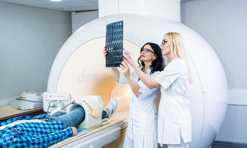 Radiologe mit männlichen Patienten, die einen Mini-Scan prüfen stockfoto