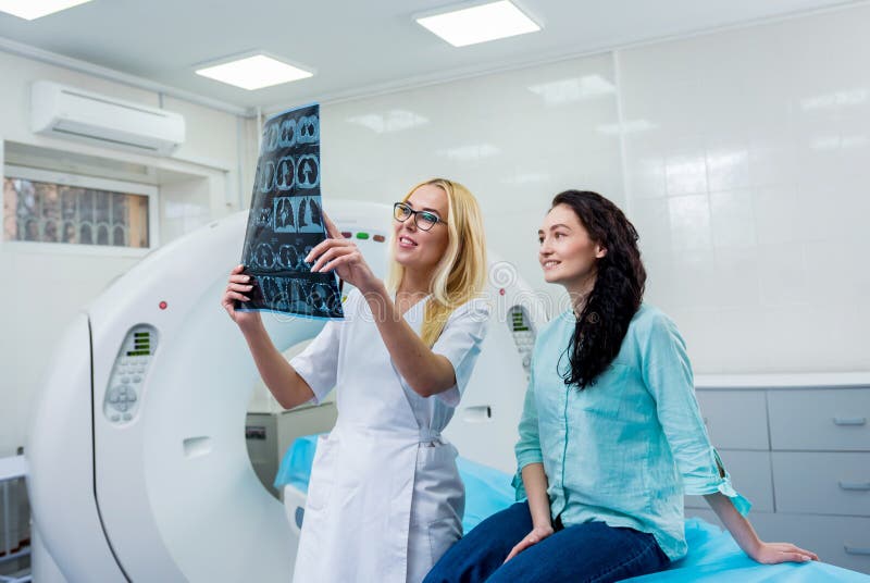 Radiologe mit einem weiblichen Patienten, der einen ct-Scan überprüft lizenzfreies stockbild