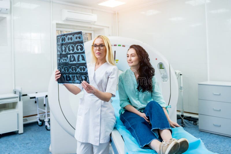 Radiologe mit einem weiblichen Patienten, der einen ct-Scan überprüft stockfotos