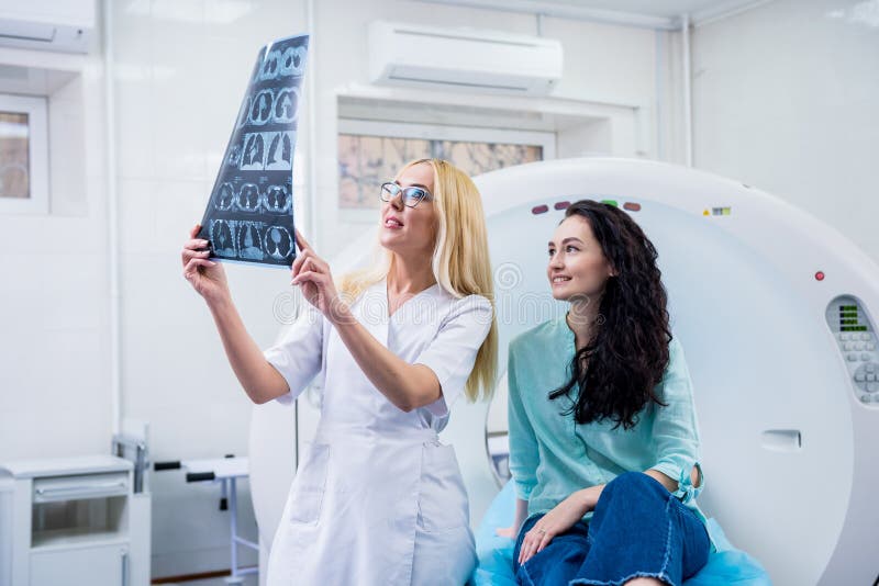Radiologe mit einem weiblichen Patienten, der einen ct-Scan überprüft stockfotografie