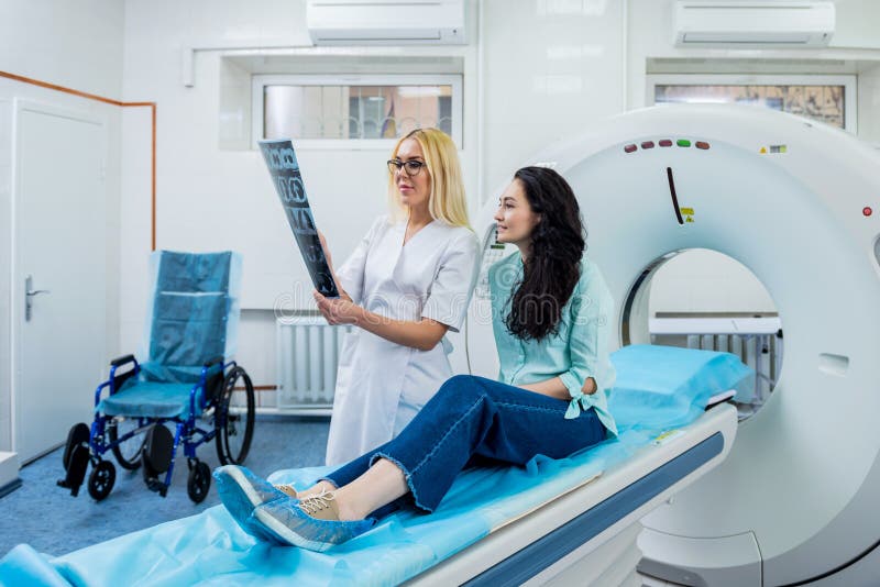 Radiologe mit einem weiblichen Patienten, der einen ct-Scan überprüft stockfotos