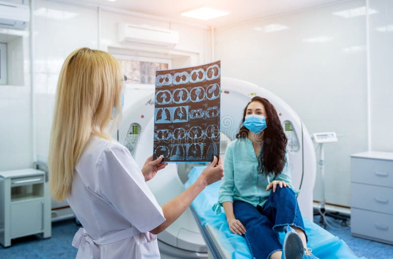 Radiologe mit Portieren Schutzmasken eines weiblichen Patienten einen ct-Scan Prüfung lizenzfreie stockfotografie