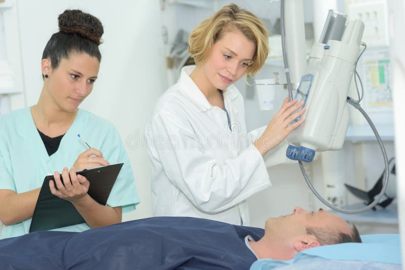 Radiologic technician with doctor during magnetic resonance exam procedure woman. Radiologic technician with doctor during magnetic resonance exam procedure woman