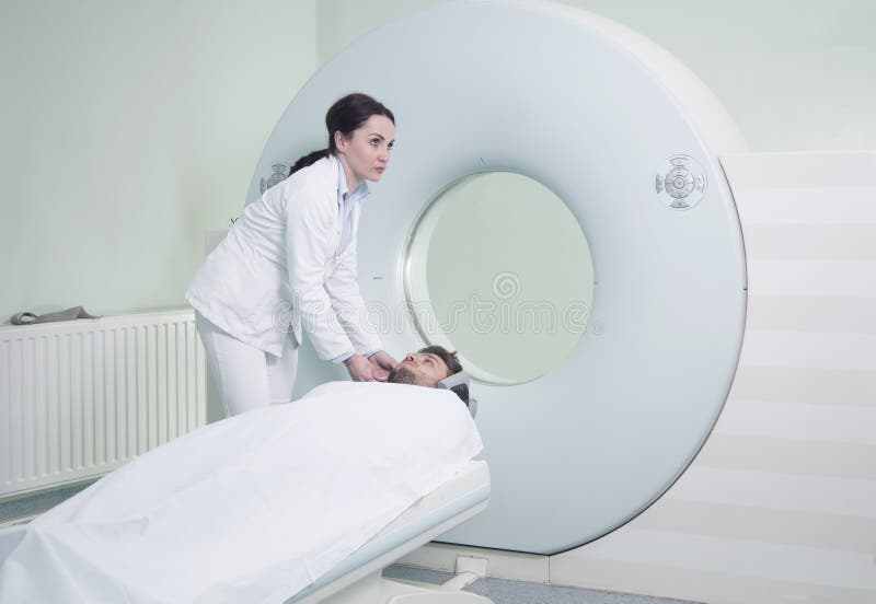 Radiologic technician and Patient being scanned and diagnosed on CT scanner in hospital. Radiologic technician and Patient being scanned and diagnosed on CT scanner in hospital.