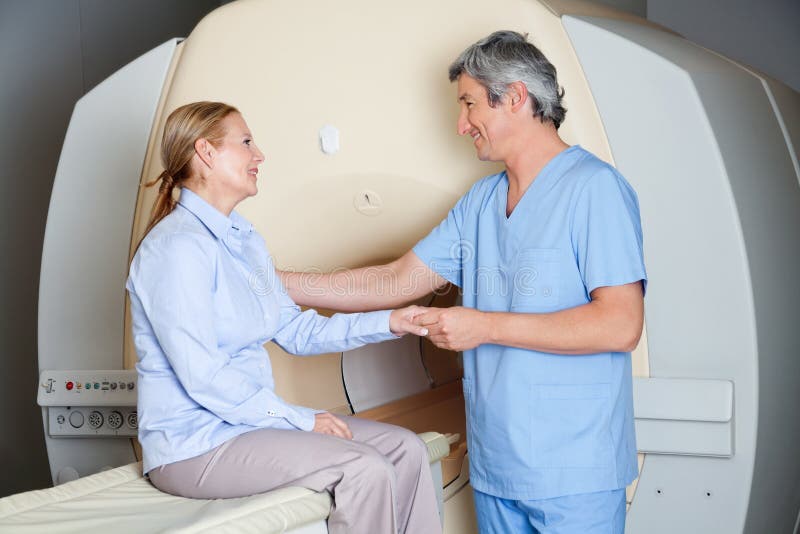 Male radiologic technician comforting female patient before MRI scan. Male radiologic technician comforting female patient before MRI scan