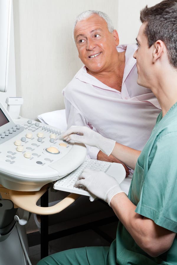 Radiologic technologist with senior patient looking at ultrasound machine. Radiologic technologist with senior patient looking at ultrasound machine