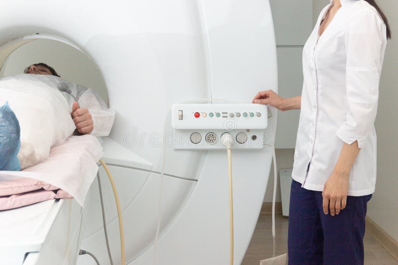 Radiologic technician and man patient lying on a CT Scan bed. preparing for MRI magnetic resonance imaging in a hospital. Radiologic technician and man patient lying on a CT Scan bed. preparing for MRI magnetic resonance imaging in a hospital.