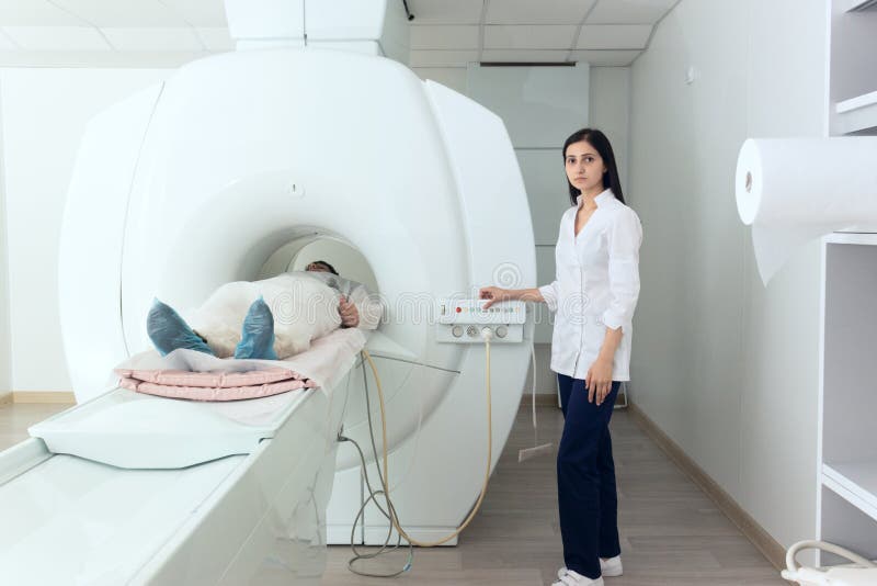 Radiologic technician and men patient lying on a CT Scan bed. preparing for MRI magnetic resonance imaging in a hospital. Radiologic technician and men patient lying on a CT Scan bed. preparing for MRI magnetic resonance imaging in a hospital.