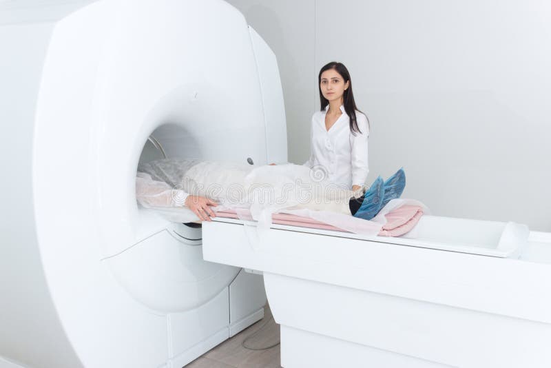 Radiologic technician and men patient lying on a CT Scan bed. preparing for MRI magnetic resonance imaging in a hospital. Radiologic technician and men patient lying on a CT Scan bed. preparing for MRI magnetic resonance imaging in a hospital.