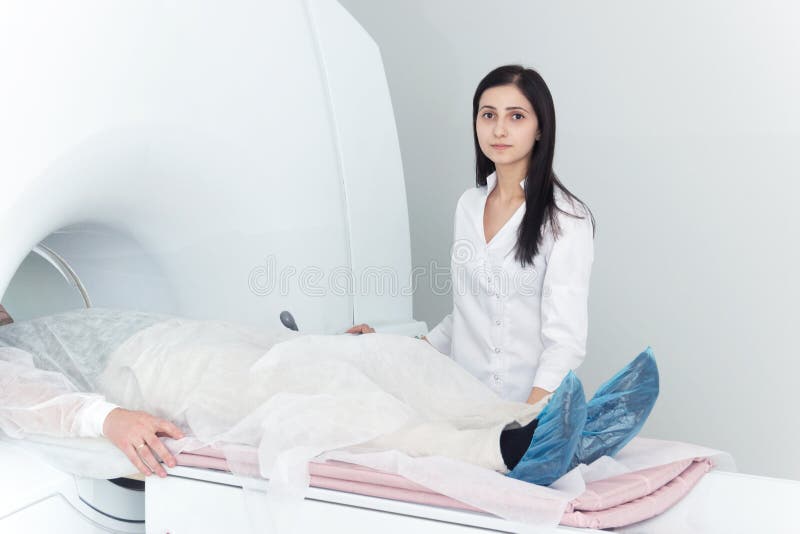 Radiologic technician and men patient lying on a CT Scan bed. preparing for MRI magnetic resonance imaging in a hospital. Radiologic technician and men patient lying on a CT Scan bed. preparing for MRI magnetic resonance imaging in a hospital.